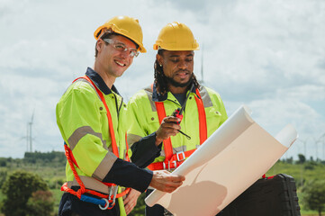 Two men in safety gear are looking at  piece of paper