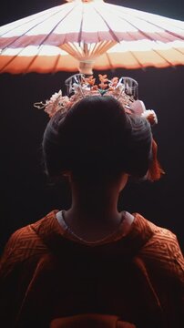 Japanese Woman In Traditional Kimono Standing Under Spotlight Holding Pink Umbrella Wearing Fox Mask Slowly Turning Head Into Darkness Symbolizing Mystery Spirit And Shadow Of Japan