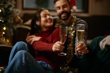 Close up of couple toasting with champagne on New Year's Eve at home.