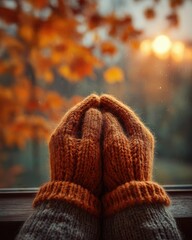 Winter Preparations Begin, hands in warm orange knit gloves resting near window with autumn leaves and soft sunset glow, capturing seasonal transition, cozy personal rituals and mindful readiness