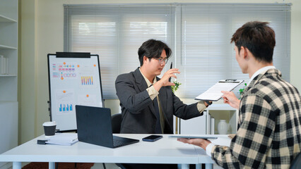 Two businessmen discussing business growth using tablet and document , perfect for a business presentation or report.