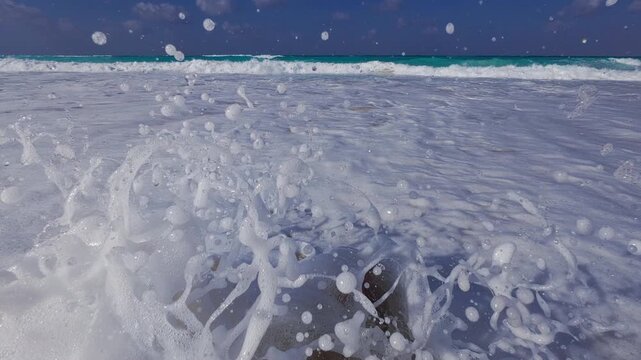 Personal point of view of man sitting on sandy beach. Tide waves slightly splash to male feet. Man sits on the beach wide angle real time footage. North Coast of Egypt, Marsa Matrouh governorate