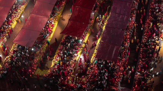 Drone top view showing massive Chhath Puja gathering in Bihar. Devotees offer sunrise prayers near water under golden morning light.
