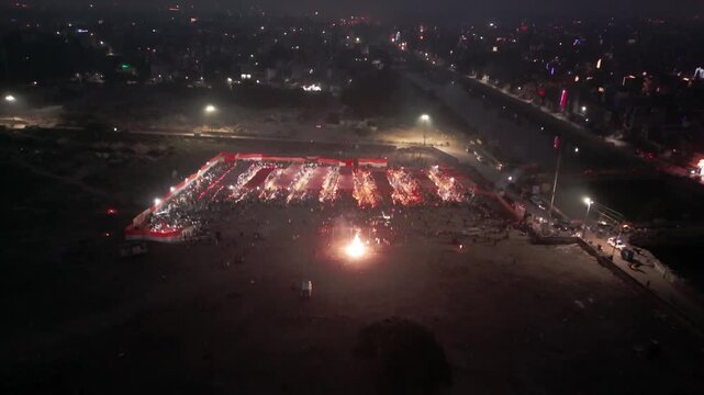 Aerial drone shot of makeshift Chhath Ghat in city. People offer morning Arghya beside small temporary water setup filled with diyas and offerings.