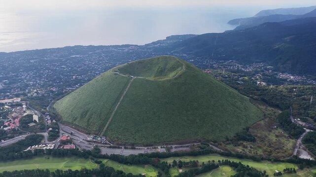 大室山の雄大な火口を見下ろす空撮映像
