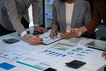 Teamwork process, Business team using a calculator to calculate the numbers of statistic business profits growth rate on documents graph data, desk in the office.