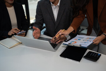 Businessmen team or financial data analysts working with tablets and laptop computers and data...