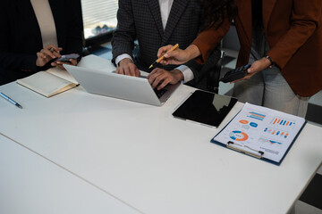 Businessmen team or financial data analysts working with tablets and laptop computers and data...