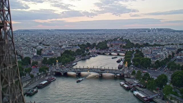 ultra-wide aerial video tracking forward over the iconic eiffel tower & parisian cityscape at dusk. serene seine river reflects golden city lights. cinematic paris romance