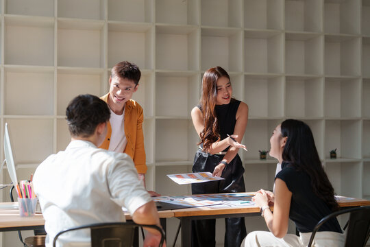 Young professionals collaborating on creative project in office - Powered by Adobe