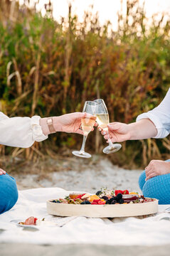 Champagne toast and charcuterie by the beach at sunset