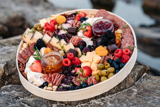 Close-up of colorful charcuterie board with meats, cheeses, and fruit.