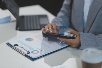 Asian Businesswoman Using laptop computer and working at office with calculator document on desk,...