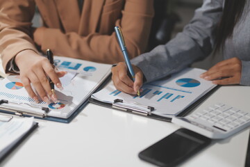 Close up Business woman using calculator and laptop for do math finance on wooden desk, tax, accounting, statistics and analytical research concept