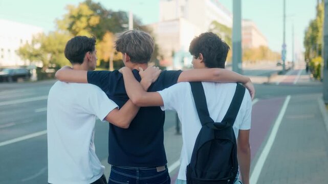 Teenage boys walking together with arms around shoulders in urban street vibe