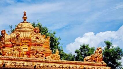 Magnificent golden temple gopuram shining under the clear blue sky in Madurai, Tamil Nadu,...