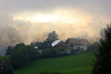 Morning mist in autumn rises in the beautiful village of Terenten, South Tyrol, Italy