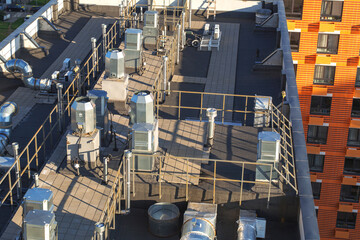 Modern building rooftop with ventilation air conditioning systems, industrial metal pipes, and...