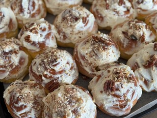 Fresh cinnamon rolls topped with creamy frosting and sprinkled with cinnamon.