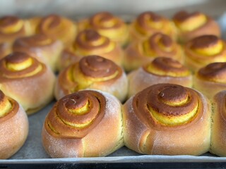 Close-up of freshly baked cinnamon rolls, soft and fluffy pastries in warm light.