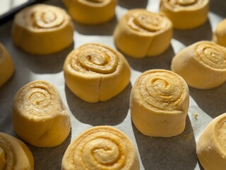 Freshly baked cinnamon rolls on a baking tray, golden and soft sweet buns.