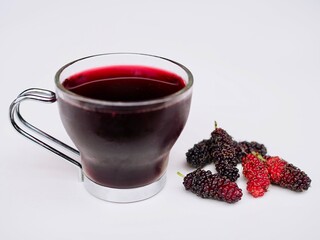 Mulberry juice is in a gass placed on a white background. Healthy fruit.