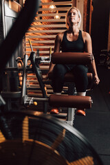 Caucasian fitness woman using a leg press machine in a gym, focused workout