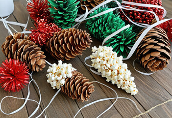 DIY kids' Christmas decorations: painted pine cones, popcorn strings, and paper chains