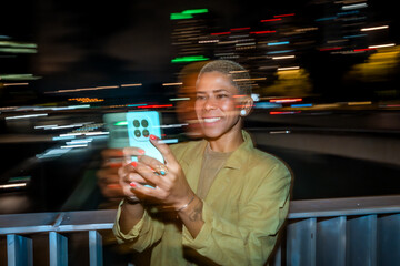 Woman capturing city lights with smartphone at night