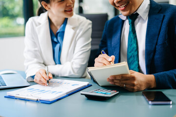 Fototapeta premium Business documents on office table with smart phone and calculator digital tablet and graph business with social network diagram and two colleagues discussing data