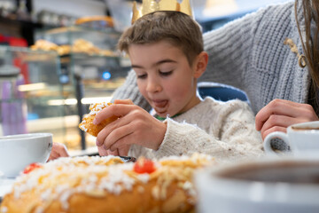 Boy king enjoying roscón de reyes cake during epiphany celebration