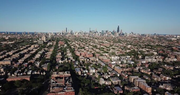 Aerial drone video from the suburbs showing the Chicago, Illinois skyline on the distant horizon as the drone is moving backwards and further away.