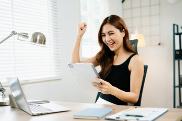 Obraz premium Asian business woman are delighted and happy with the work they do on their tablet, laptop and taking notes at the office.