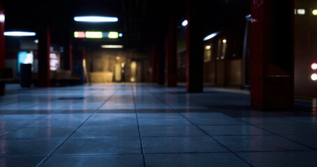 An abandoned subway station is partially illuminated by cool blue lights. The glossy tiled floor reflects the dim surroundings, enhancing the eerie atmosphere as no passengers are seen.