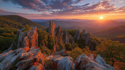 Dramatic sunset over rocky mountain peaks and forested valleys