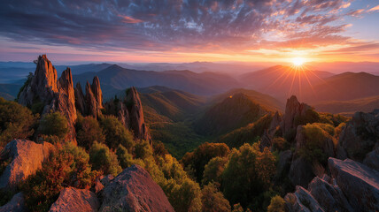 Sunrise over a rugged mountain range with dramatic clouds and sun rays