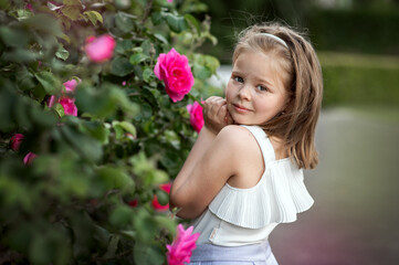 Beautiful Girl in Garden with Pink Roses