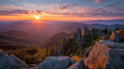 Dramatic sunset over a rocky mountain range with sunburst effect