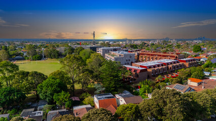 Panorama Sunset  aerial drone view of western Sydney Suburbs of Canterbury Burwood Ashfield Marrickville Campsie with Houses roads and parks in Sydney New South Wales NSW Australia
