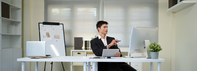 Serious, business man and thinking on computer in office, internet research and website. Focused male employee, desktop and solution of ideas, planning decision and review strategy, project or vision