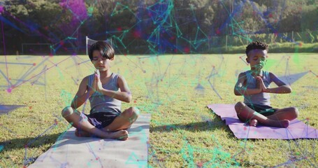 Naklejka premium Meditating boys practicing prayer yoga on yoga mats in park field, with geometric overlay