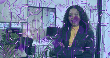 Standing confident woman wearing blazer behind purple circuit board partition in office, copy space