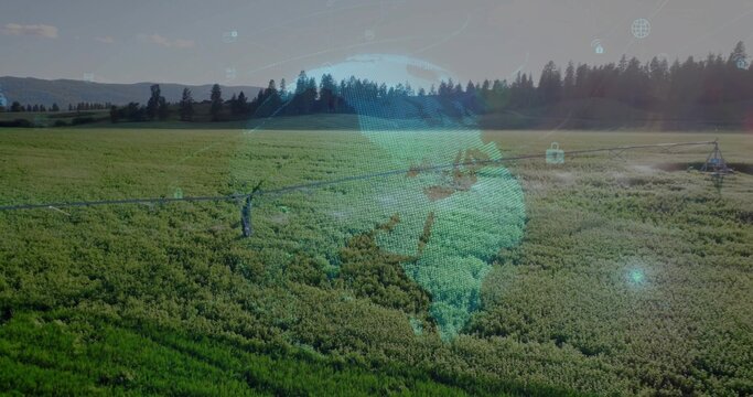Spraying center pivot pipe watering rural farm, with holographic globe, padlock and network icons