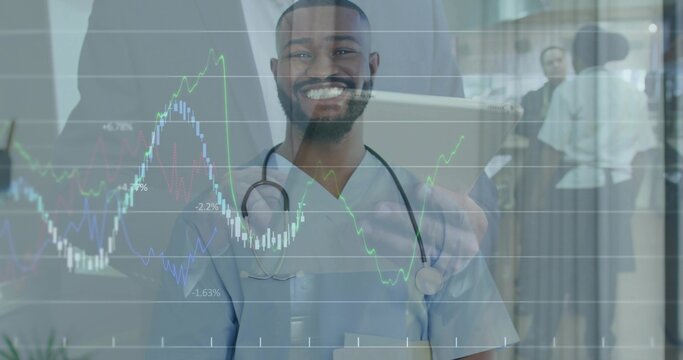 Doctor in scrubs checking financial overlay on tablet in hospital hall with stethoscope