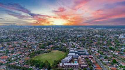 Panorama Sunset  aerial drone view of western Sydney Suburbs of Canterbury Burwood Ashfield Marrickville Campsie with Houses roads and parks in Sydney New South Wales NSW Australia