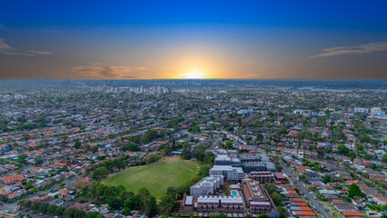 Fototapeta premium Panorama Sunset aerial drone view of western Sydney Suburbs of Canterbury Burwood Ashfield Marrickville Campsie with Houses roads and parks in Sydney New South Wales NSW Australia