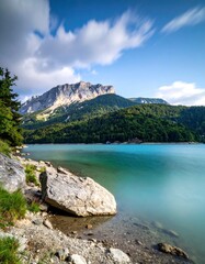Idyllic Lake Scene with Mountain Backdrop and Serene Waters.