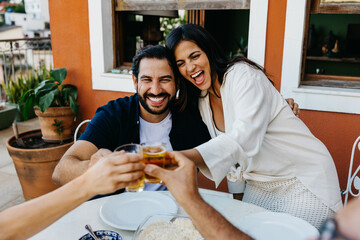 Happy couple celebrating with drinks at a cozy outdoor barbecue gathering