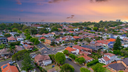 Fototapeta premium Panorama Sunset aerial drone view of western Sydney Suburbs of Canterbury Burwood Ashfield Marrickville Campsie with Houses roads and parks in Sydney New South Wales NSW Australia