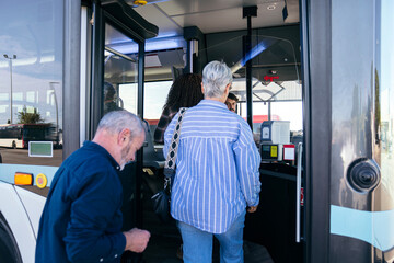 People of different generations boarding a city bus. Seniors using public transportation, traveling in an urban environment